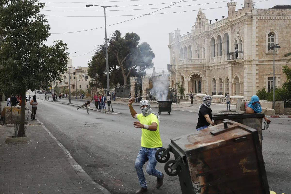 Palestinians clash with Israeli troops in front of the Intercontinental hotel in the West Bank city of Bethlehem on Oct. 23, 2015. (AP Photo/Nasser Shiyoukhi)