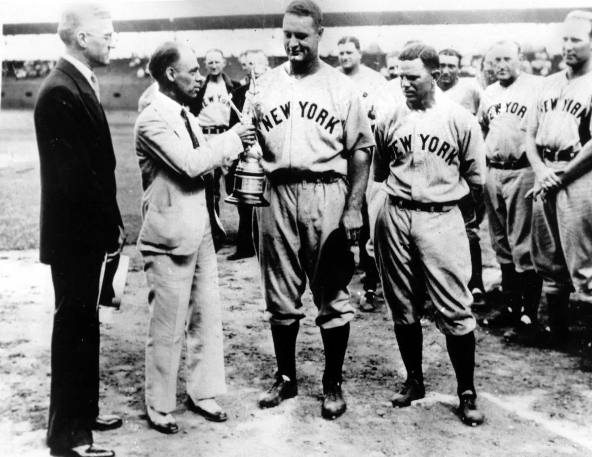 Lou Gehrig, first baseman for the New York Yankees, received a trophy in St. Louis, Aug. 17, 1933 when he played his 1,308th consecutive major league game. Left to right: President William Harridge of the American League; Edgar G. Brands, St. Louis newspaperman; Gehrig; and Joe Sewell, teammate of the new record holder. (AP Photo)