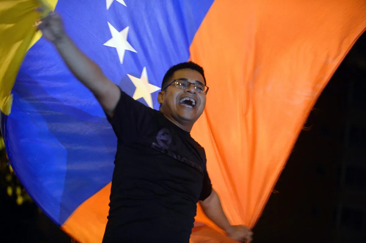 Venezuelan opposition supporters celebrate the results of the legislative election in Caracas, on Dec. 7, 2015. Venezuela's opposition won at least a majority of 99 out of 167 seats in the state legislature, electoral authorities said Monday, the first such shift in power in congress in 16 years. (Federico Parra/AFP/Getty Images)