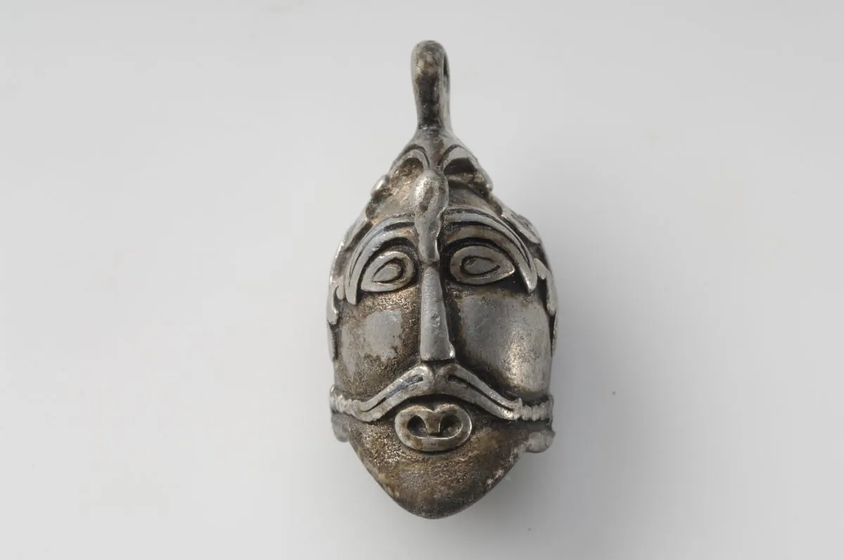 This silver pendant in the shape of a man’s head comes from a unique grave find containing objects of precious metals that mark the deceased as someone of great importance. Close inspection reveals he wears a bird atop his head with its wings extending down to his ears. (© The Swedish History Museum)