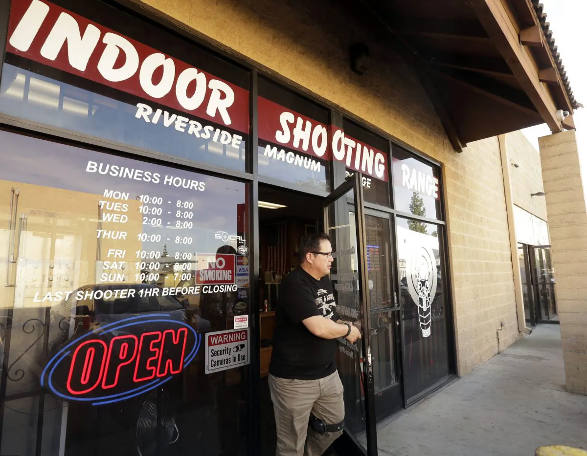 John Galletta, a firearms instructor at Riverside Magnum Range, opens a door at the range on Monday, Dec. 7, 2015, in Riverside, Calif. (AP Photo/Nick Ut)