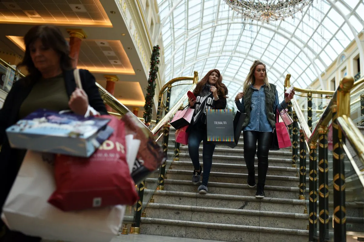 Shoppers walk through the Trafford Centre shopping mall past retailers offering 'Black Friday' discounts in Manchester, northern England on November 27, 2015 (Oli Scarff/AFP/Getty Images)