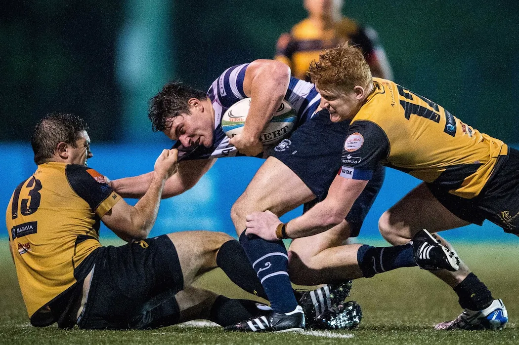 HKFC winger Charles Higson-Smith bundled up by Tigers ctrs Braam Gerber (l) and Sam Purvis in their HKRFU Premiership match at Kings Park on Saturday Dec 5, 2015. Borelli Walsh USRC Tigers won the match 24-18. (HKRFU)