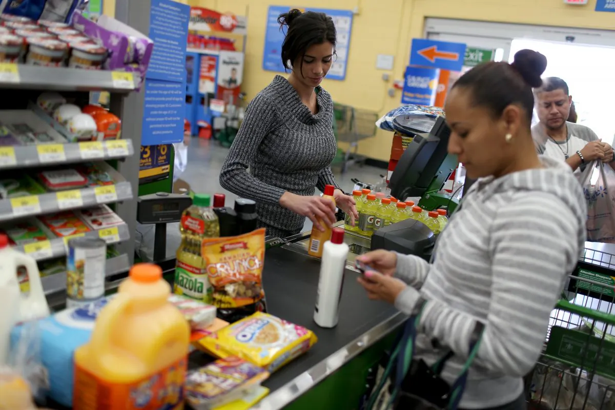 Walmart employee Darlin Cienfuegos rings up customer purchases at a Walmart store on Feb. 19, 2015 in Miami, Florida. (Joe Raedle/Getty Images)