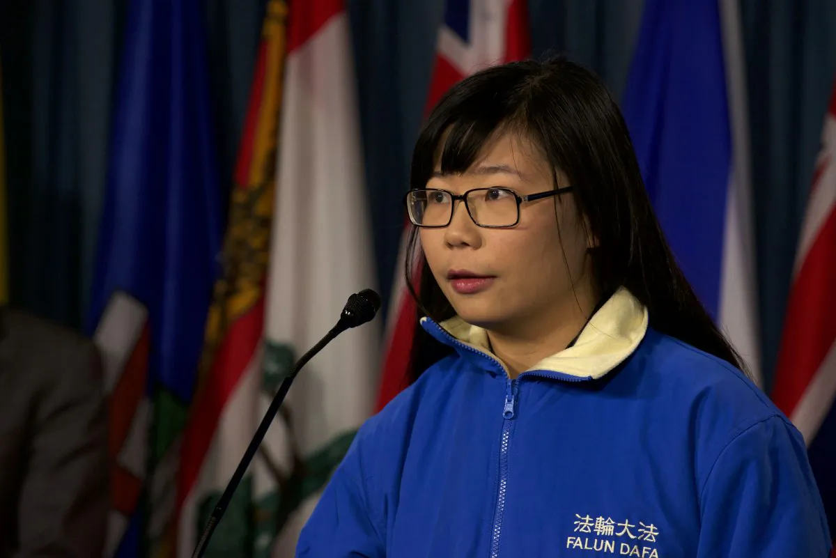 Hope Chen speaks to reporters on Parliament Hill on Dec. 9. The 22-year-old is trying to draw attention to the plight of her father who was imprisoned in China for suing former Chinese leader Jiang Zemin. Chen has been threatened by a Chinese agent for discussing his detention in the media. (Matthew Little/Epoch Times)