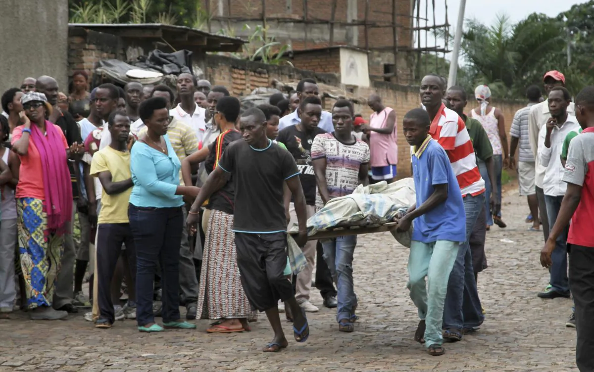 Men carry away a dead body in the Nyakabiga neighborhood of Bujumbura, Burundi, Saturday, Dec. 12, 2015. Burundi's political violence continued Saturday as a number of people were found shot dead in the Nyakabiga neighborhood of the capital, a day after the government said an unidentified group carried out coordinated attacks on three military installations. (AP Photo)