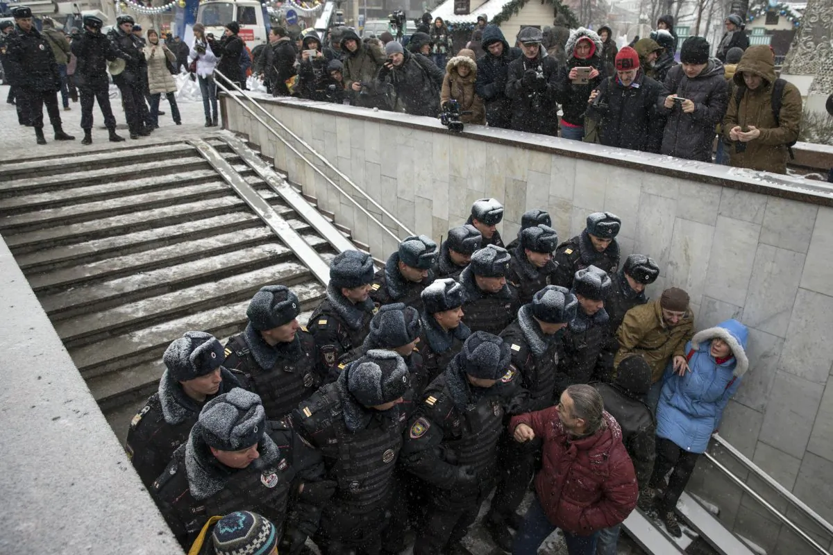 Police officers block the way to prevent people attending an opposition rally in Pushkin Square in Moscow, Russia, Saturday, Dec. 12, 2015. Police report that over a dozen participants in an opposition rally held in support of the Russian constitution were detained. The Day of the Constitution is marked on Dec. 12 in Russia. (AP Photo/Pavel Golovkin)