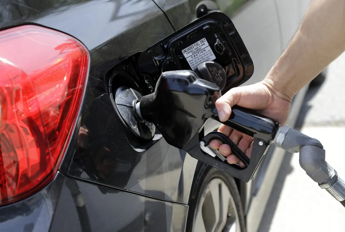 Gas station attendant Carlos Macar pumps gas in Andover, Mass., on May 8, 2015. Gasoline is close to breaking below a key psychological barrier as drivers enjoy some of the cheapest pump prices since the recession. The nationwide average price of a gallon of regular Saturday, Dec. 12, 2015, was $2.02, down 58 cents from this time last year, according to auto club AAA. Experts say it could drop below $2 in the coming days. (AP Photo/Elise Amendola)