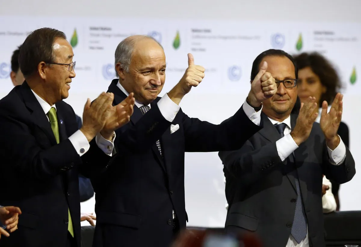 French foreign minister and President of the COP21 Laurent Fabius (C) applauds while United Nations Secretary General Ban Ki-moon (L) and French President Francois Hollande applaud after the final conference of the COP21, the United Nations conference on climate change, in Le Bourget, north of Paris, Saturday, Dec.12, 2015.  (AP Photo/Francois Mori)