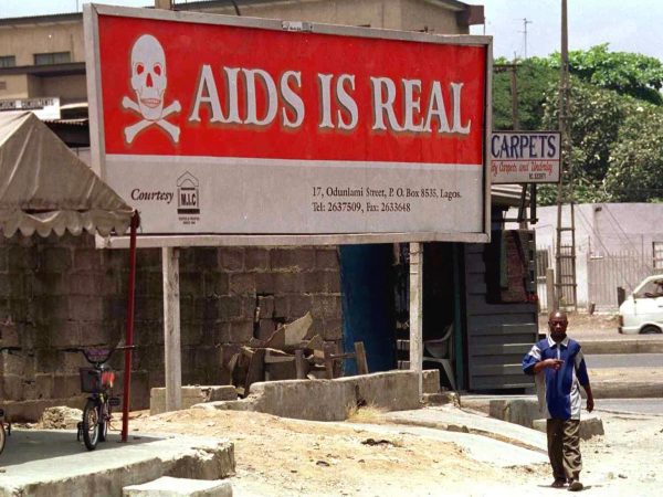 A man walks past a signboard warning residents that the threat of HIV/AIDS is real in Lagos, Nigeria, on March 31, 2001. (Pius Utomi Ekpei/AFP/Getty Images)