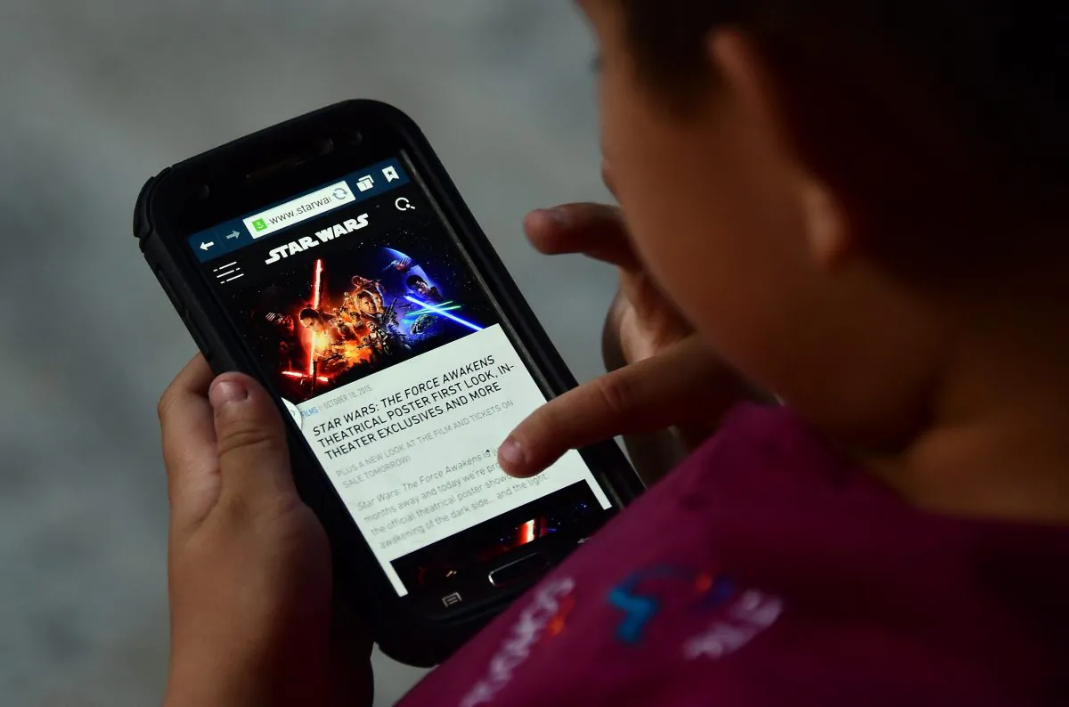 A child browses on a mobile phone Oct. 20 2015 in Los Angeles. (Photo credit should read FREDERIC J. BROWN/AFP/Getty Images)
