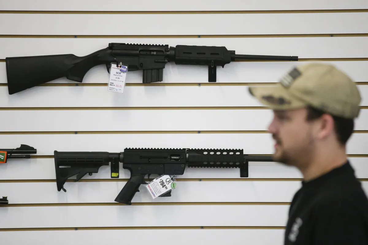 In this Dec. 9, 2015, photo, a sales associate walks past semiautomatic rifles at Bullseye Sport gun shop in Riverside, Calif. The massacre at Sandy Hook elementary school in which a mentally disturbed young man killed 26 children and teachers galvanized calls across the nation for tighter gun controls. But in the three years since, many states have moved in the opposite direction, embracing the National Rifle Associations response that more good guys with guns are whats needed to limit the carnage of mass shootings. (AP Photo/Jae C. Hong)