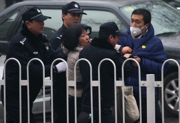 A supporter of rights lawyer Pu Zhiqiang scuffles with policemen near the Beijing Second Intermediate People's Court during Pu's trial in Beijing on Dec. 14, 2015. (AP Photo/Andy Wong)