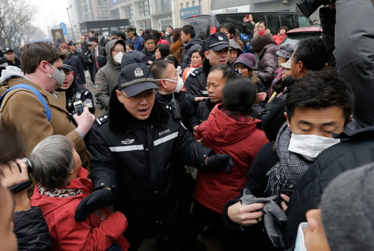 Police officers push away supporters of rights lawyer Pu Zhiqiang and foreign journalists near the Beijing Second Intermediate People's Court in Beijing, Monday, Dec. 14, 2015. (AP Photo/Andy Wong)