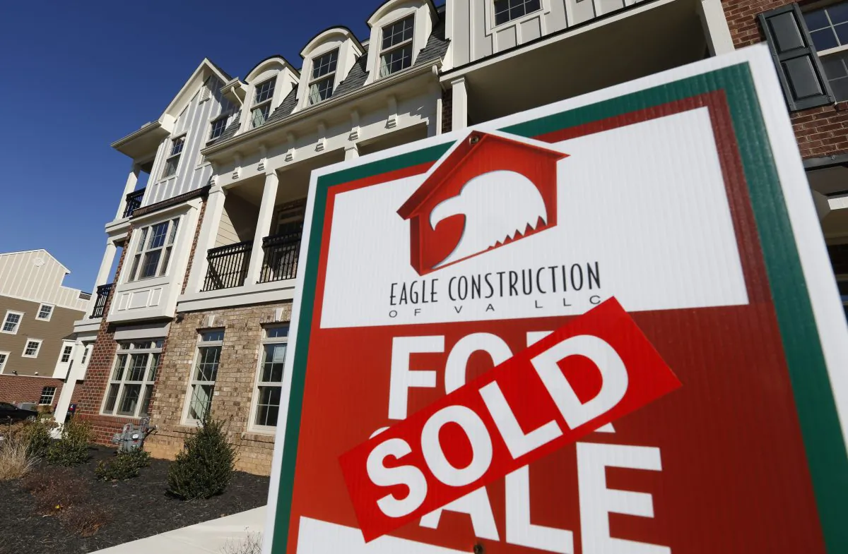 A 'Sold' sign is posted in front of a row of new town houses in Richmond, Va. on Jan. 8, 2015. (AP Photo/Steve Helber)