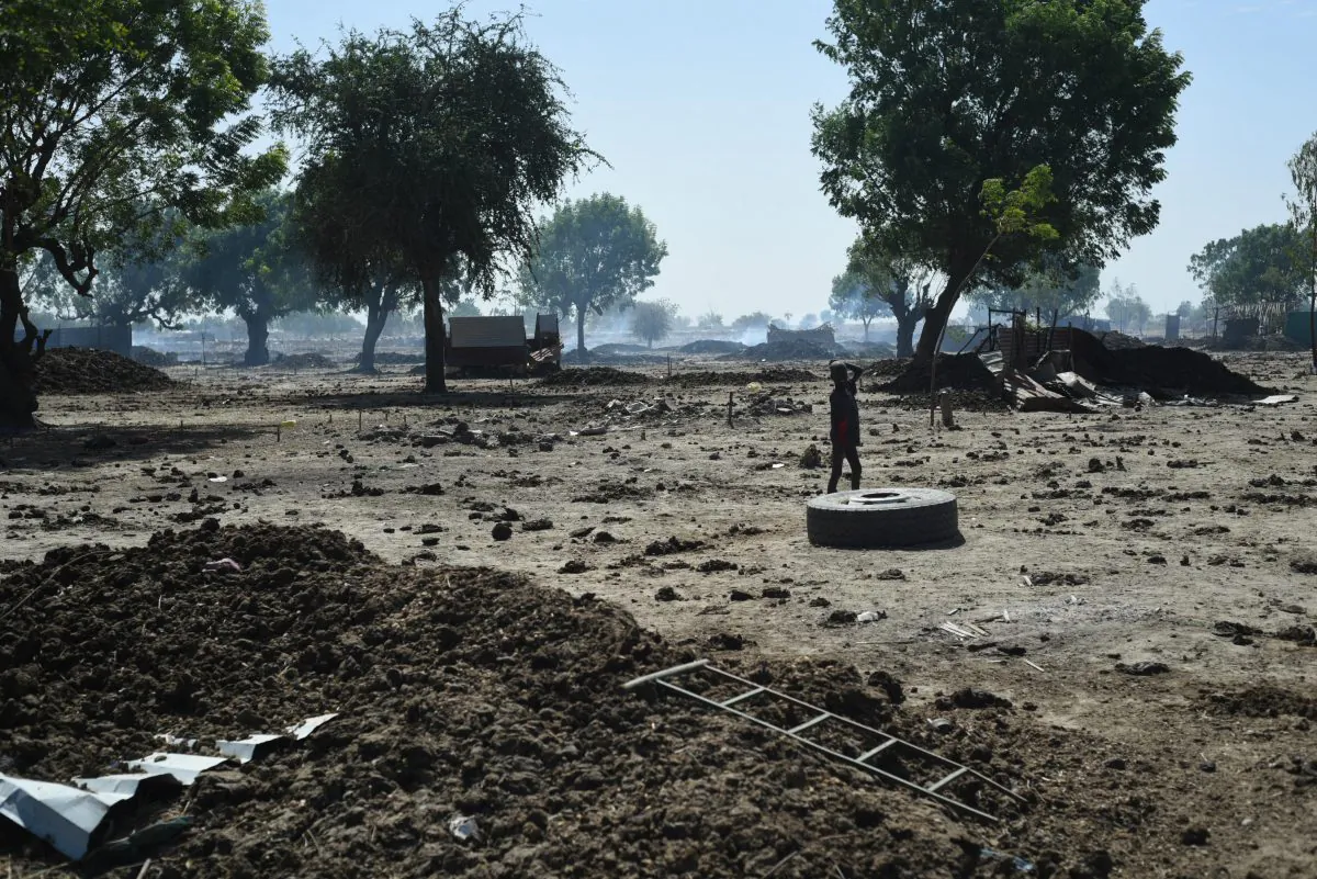 A child walks through the ruins of Leer town in South Sudan's Unity state on Dec. 15, 2015. Leer, the hometown of rebel leader Riek Machar, has been sacked at least three times during the war. Tuesday marked the two year anniversary of South Sudan's civil war. (AP Photo/Jason Patinkin)