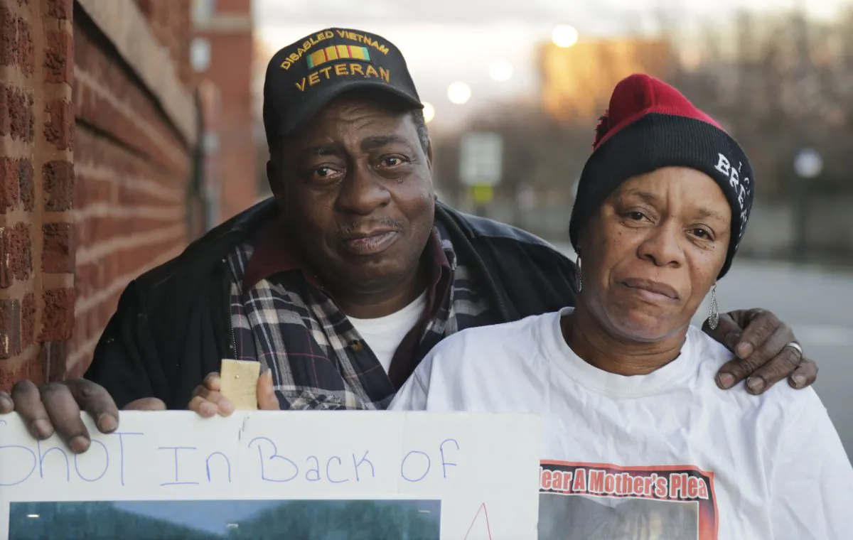 In this Wednesday, Dec. 16, 2015, photo in Chicago, Janet Lindsey Ferguson, right, and her husband Fredrick Ferguson, hold a poster bearing a photograph of her teenage son, Rickey Childs, who was shot and killed by a Chicago police officer in 2012. (AP Photo/M. Spencer Green)