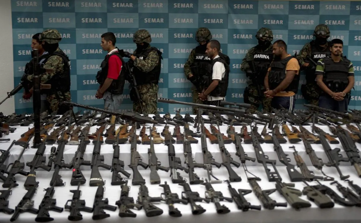 Mexican marines escort five alleged drug traffickers of the Zetas drug cartel in front seized grenades, firearms, cocaine, and military uniforms in Mexico City on June 9, 2011. (Yuri Cortez/AFP/Getty Images)