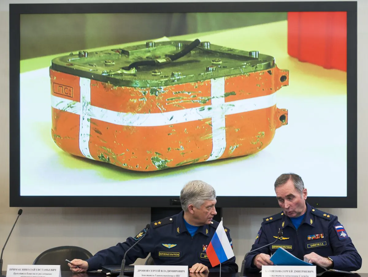 Russian aerospace forces Lt.-Gen. Sergei Dronov, left, and Lt.-Gen. Sergei Bainetov talk, as an image of a flight data recorder from the Russian warplane downed by Turkey is displayed on a screen in the background. during a news conference, in Moscow, Russia, Friday, Dec. 18, 2015. (AP Photo/Alexander Zemlianichenko)