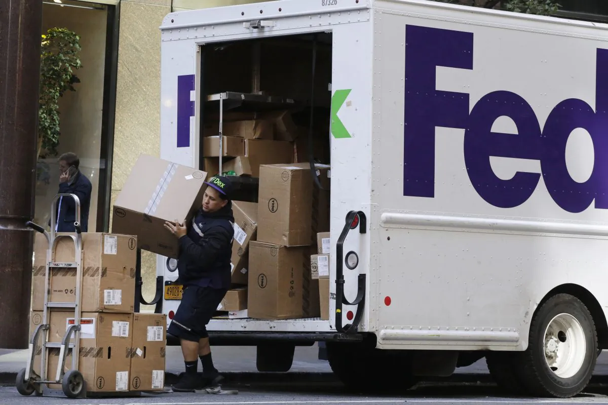 A FedEx driver loads Dell computers for delivery, Friday, Oct. 23, 2015 in New York. (AP Photo/Mark Lennihan)