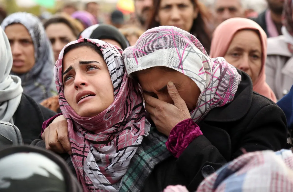 The sister (L) of Mohammed Ismael, who died in one of three recent suicide car bombings claimed by the Islamic State in the town of Tal Tamr, mourns during his funeral in Qamishli City, Hasakeh Province, Syria, on Dec. 13, 2015. (Delil Souleiman/AFP/Getty Images)