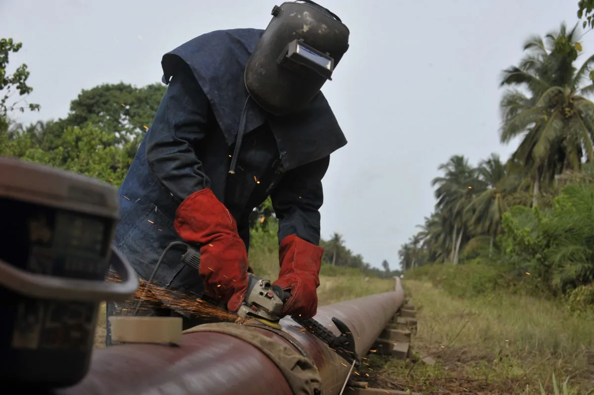 A worker welds an oil pipeline in Jacqueville Town, Ivory Coast, on May 6, 2010. (Issouf Sanogo/AFP/Getty Images)