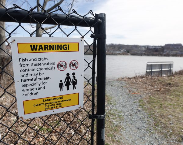 A warning sign hangs on a gate at River Park on Tuesday, April 14, 2015, in Green Island, N.Y. Environmentalists and elected officials are renewing their call for a broader PCB cleanup of the upper-Hudson in what could be the final year of dredging. General Electric is expected to begin its sixth and possibly final season of dredging next month as part of a $2 billion federal Superfund project. (AP Photo/Mike Groll)