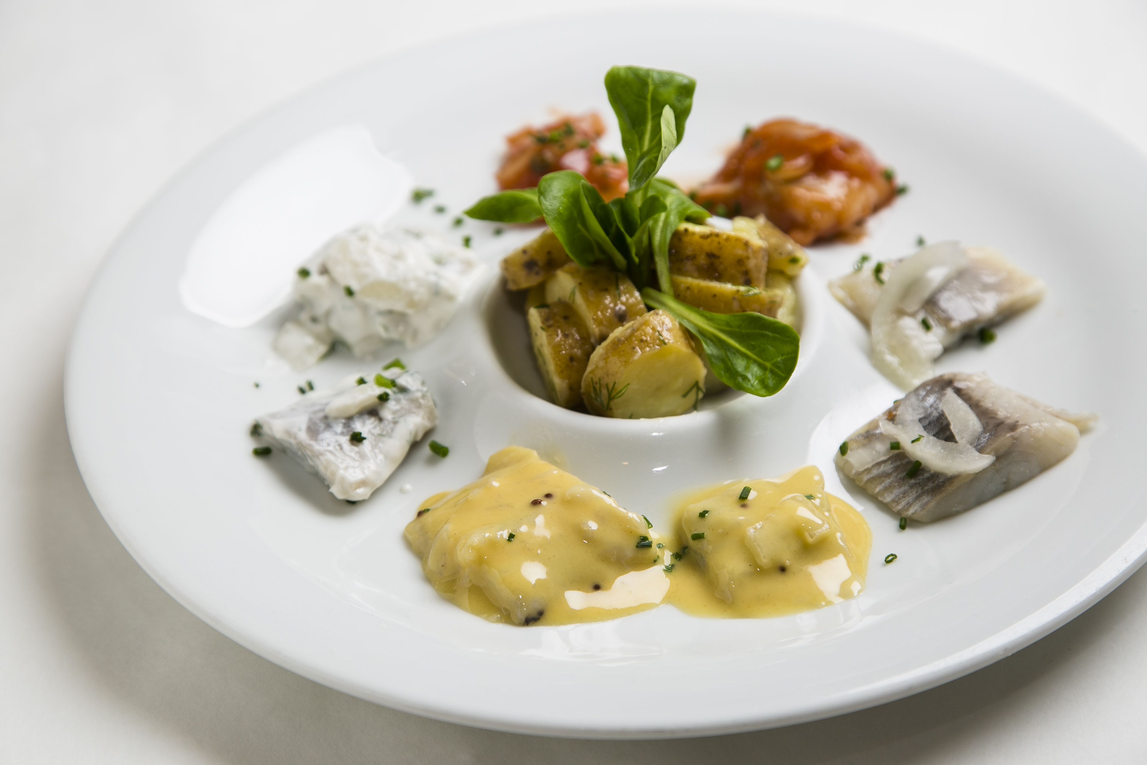 The Herring Quartet at Smorgas Chef, done four ways: pickled, in mustard, in dill and cream, and in tomato sauce. (Samira Bouaou/Epoch Times)