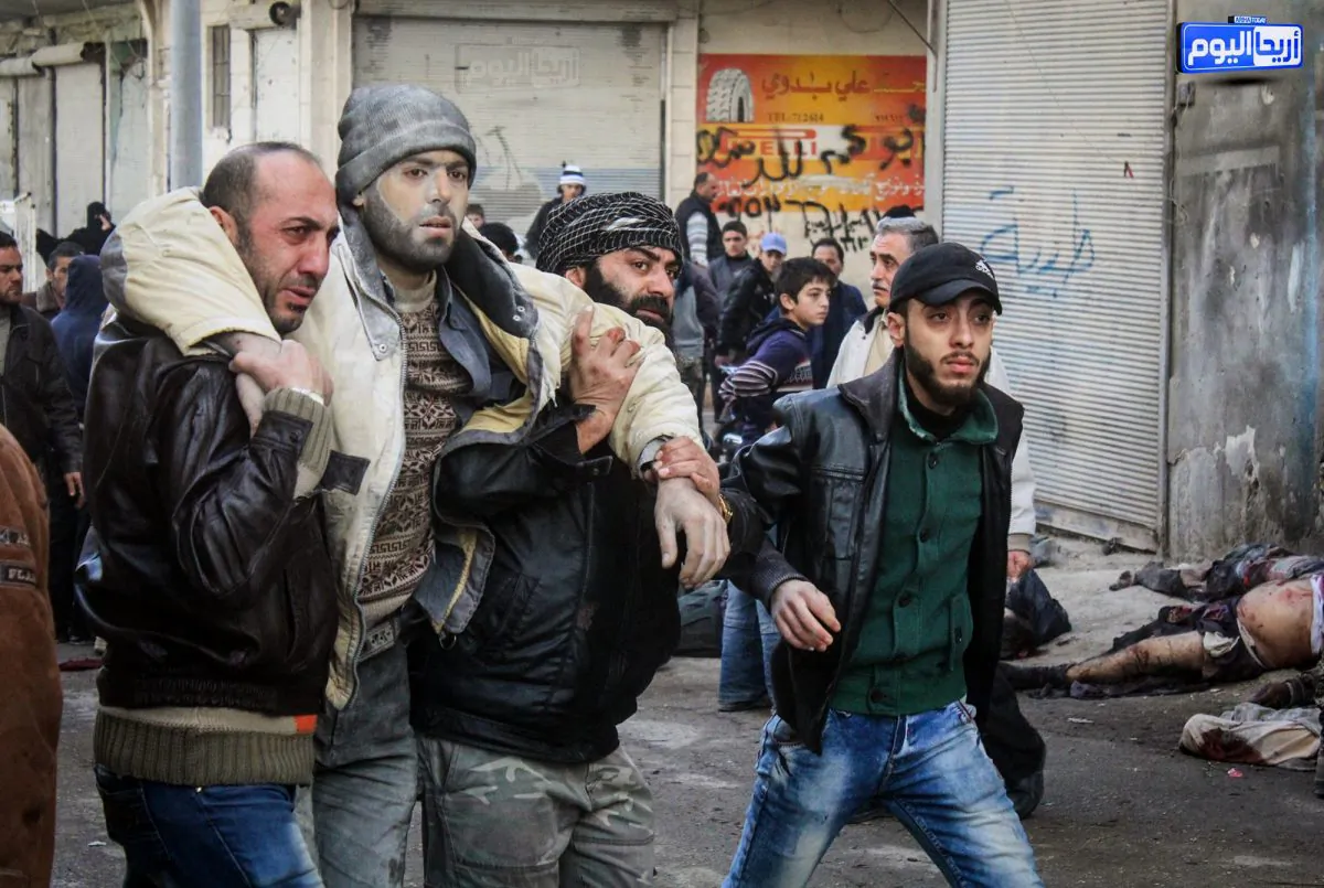 Syrian citizens help an injured man after airstrikes believed to be carried out by Russian warplanes in the town of Ariha in Syria on Nov. 29. (Ariha Today via AP)