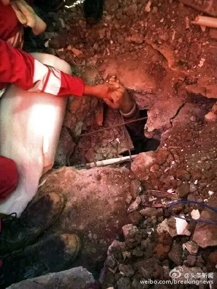 Rescue workers comfort Tian Zeming while he is waiting to be dug out in the early morning hours of Dec. 23. (Weibo.com)