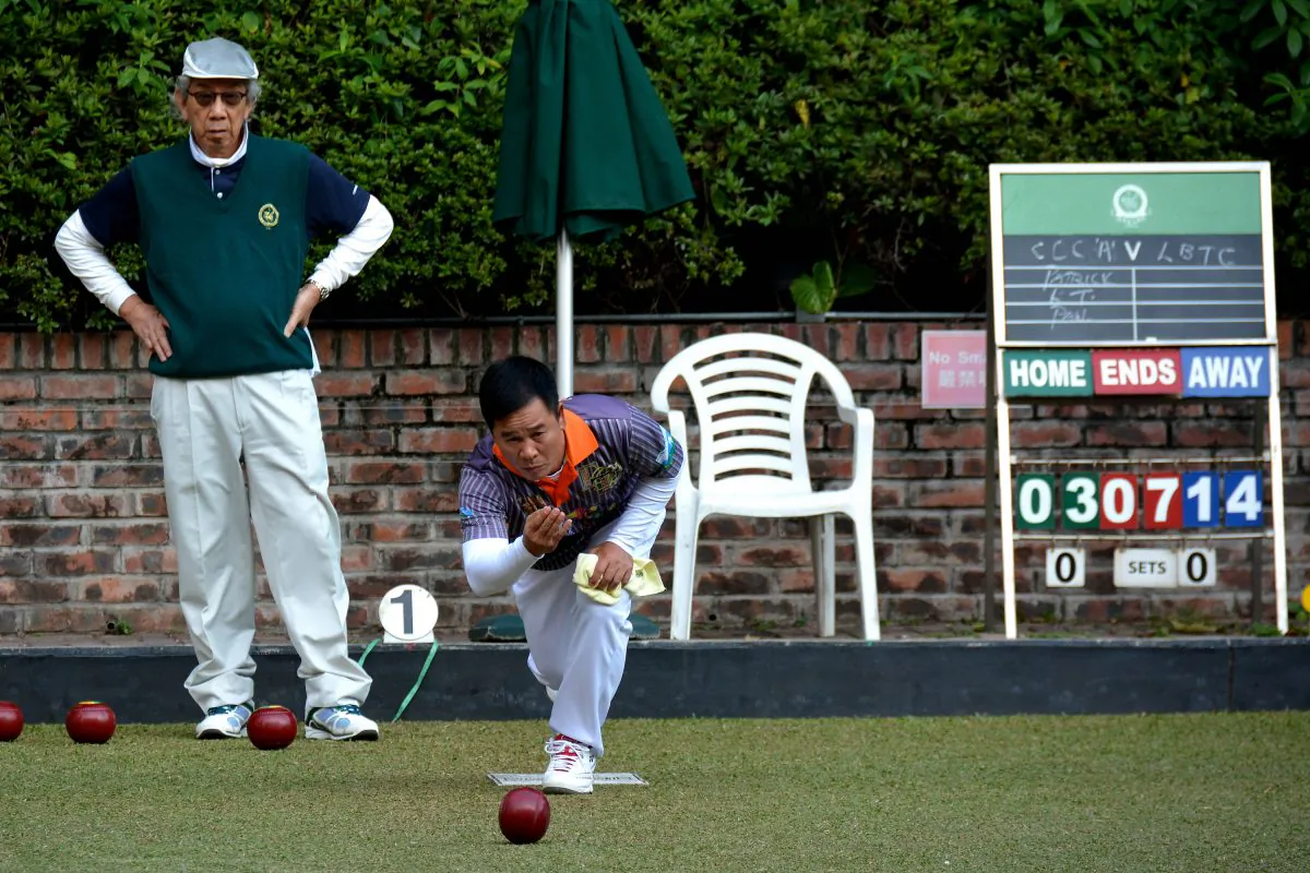 Chinese International and Lawn Bowls Training Center A-team bowler He Heng Hui (delivering) on his way to defeating Craigengower Cricket Club A’s Paul Tam in the Triples League match last Saturday, December 19, 2015. LBTC won the fixture 6-2 and is in sixth on the league table. CCC-A are currently in 8th place. (Stephanie Worth)