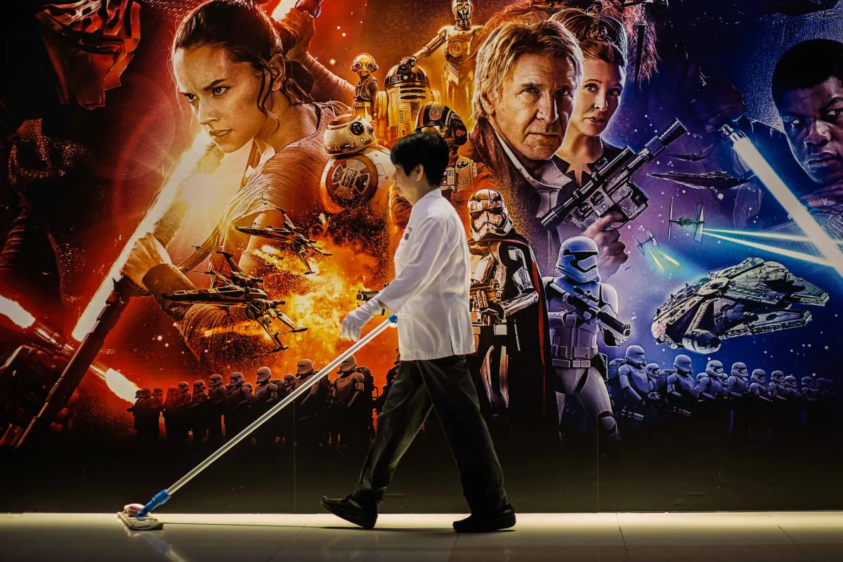 A cleaner walks past a poster advertising "Star Wars: The Force Awakens" in Hong Kong on Dec. 17, 2015. (Anthony Wallace/AFP/Getty Images)