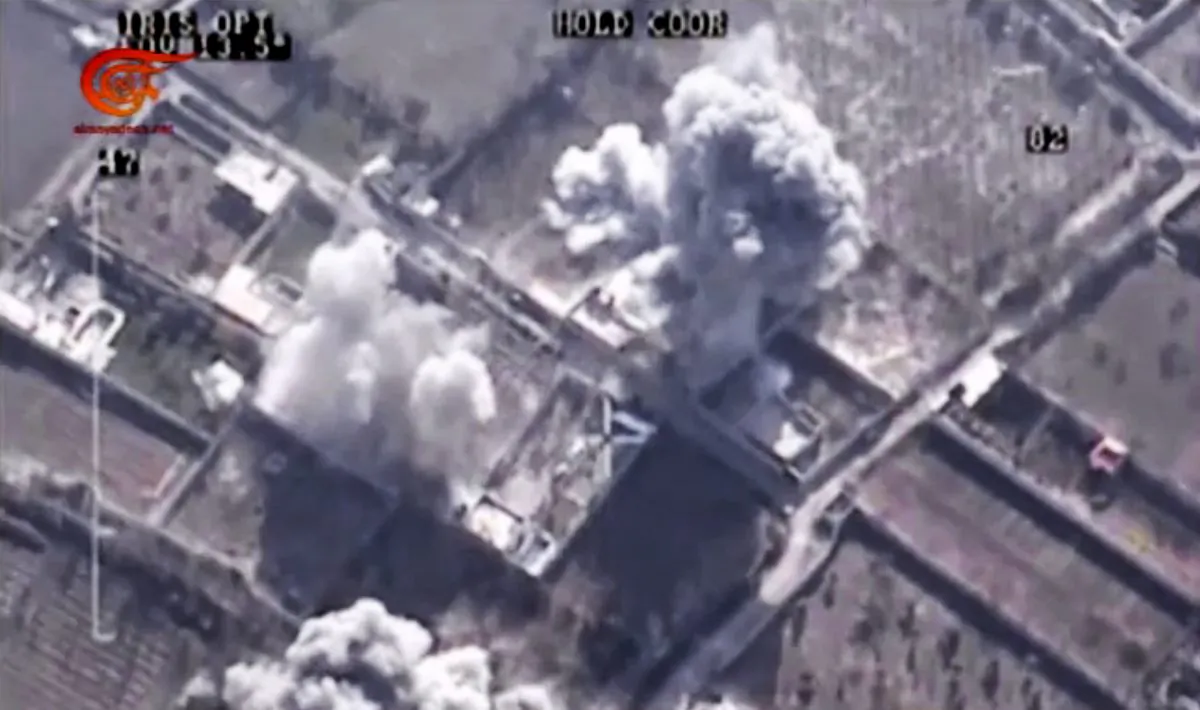 This image made from video made available on Saturday, Dec. 26, 2015, by Al-Mayadeen, government-controlled Syrian Television, which has been verified and is consistent with other AP reporting shows, drone footage allegedly showing Syrian army airstrikes targeting Zahran Allouch, the head of the Army of Islam group near Damascus, Syria. Militant groups in Syria on Saturday mourned the death of a powerful rebel commander who was killed in an airstrike near Damascus — a high profile assassination that may shift the balance of power in rebel-held suburbs of the Syrian capital. Allouch, was killed Friday, Dec. 25 in an airstrike that targeted the group's headquarters during a meeting.  (Al-Mayadeen via AP video)