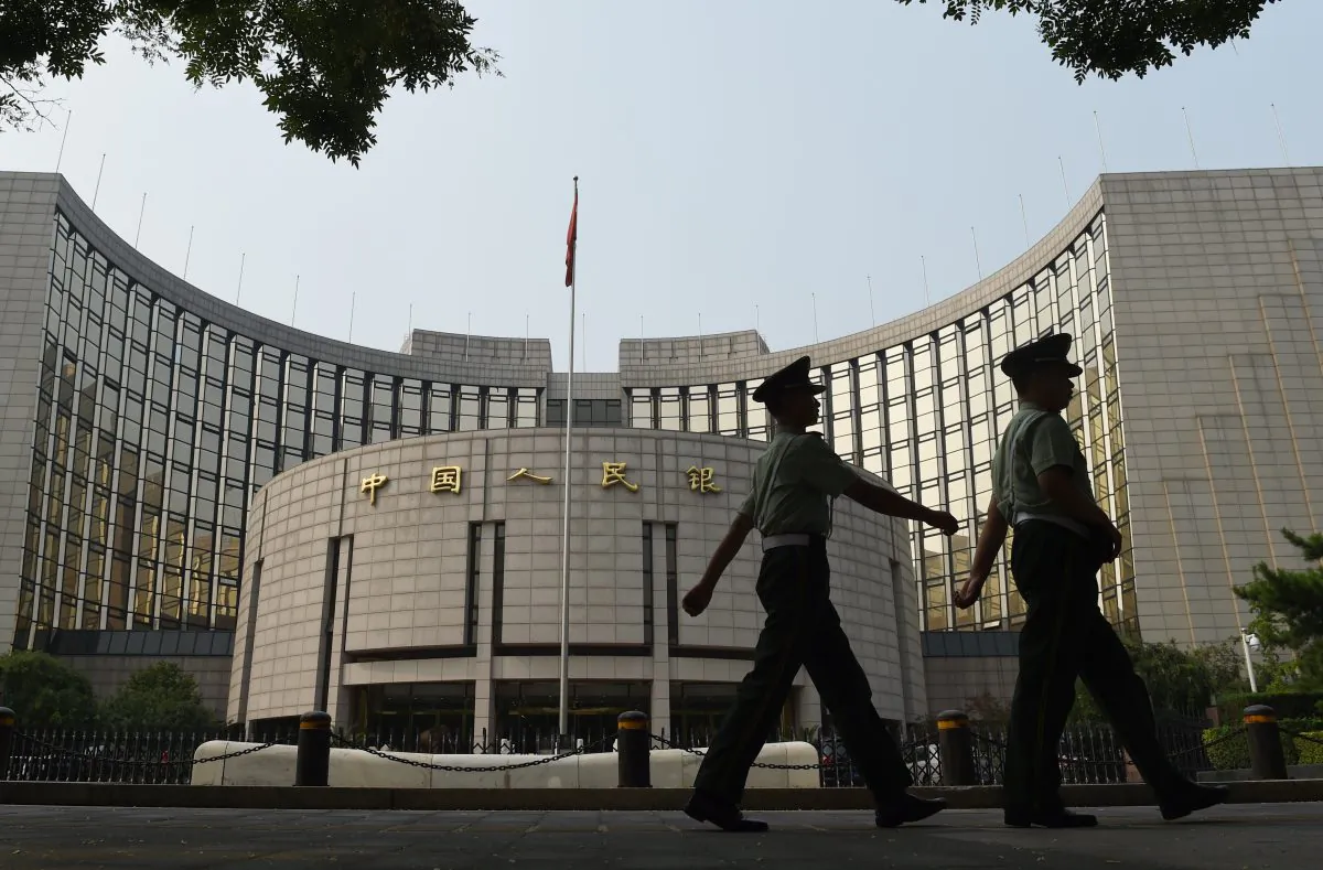 Paramilitary policemen patrol in front of the People's Bank of China, the central bank of China, in Beijing on July 8. (GREG BAKER/AFP/Getty Images)