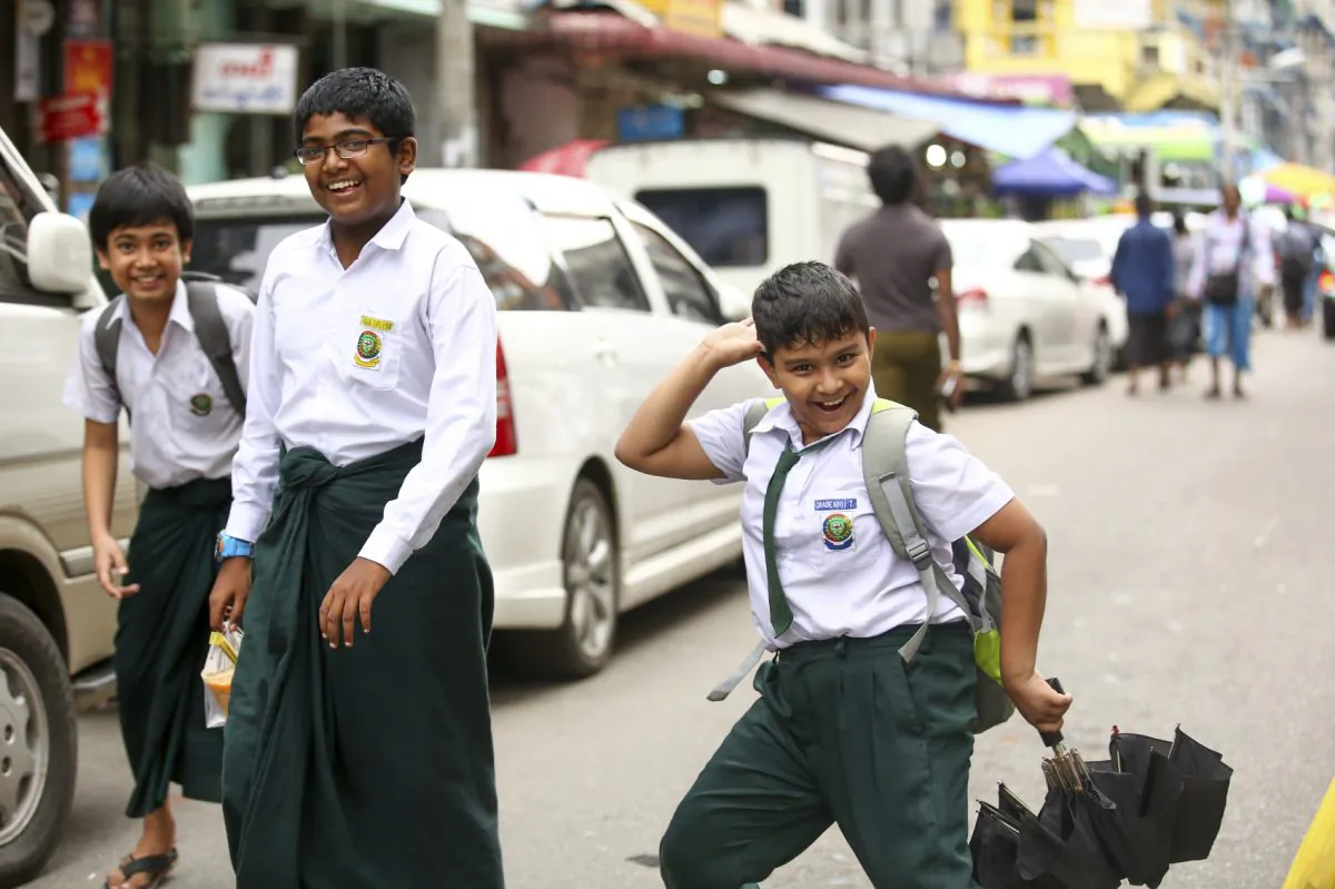 Group of joyful pupils on their way home from school on road in Yangon, Burma, on July 3, 2015. (Mhoo1990/iStock)