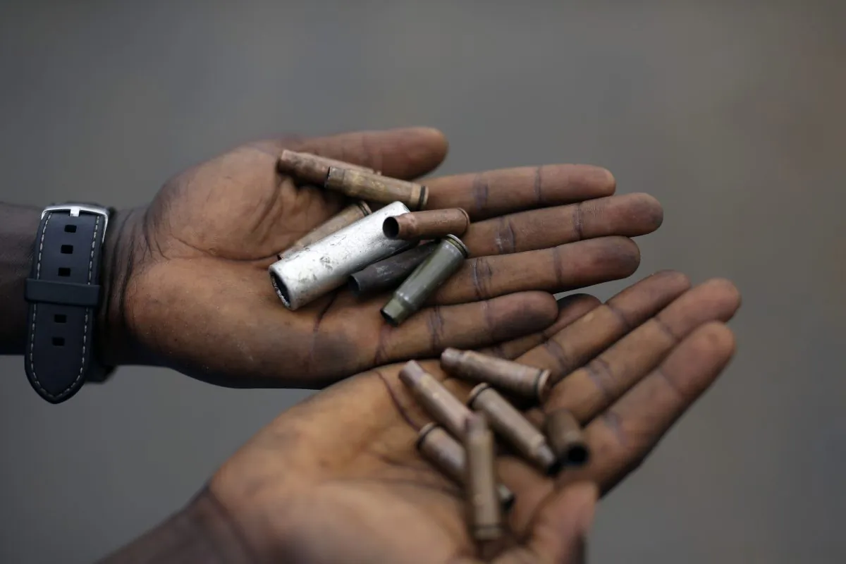 Demonstrators display cartridges from police guns fired in the Musaga neighborhood of Bujumbura, Burundi, on May 20, 2015. Police returned to the neighborhood in full force on May 20, firing live rounds and tear gas to disperse demonstrators protesting the president's decision to seek a third term. (AP Photo/Jerome Delay)