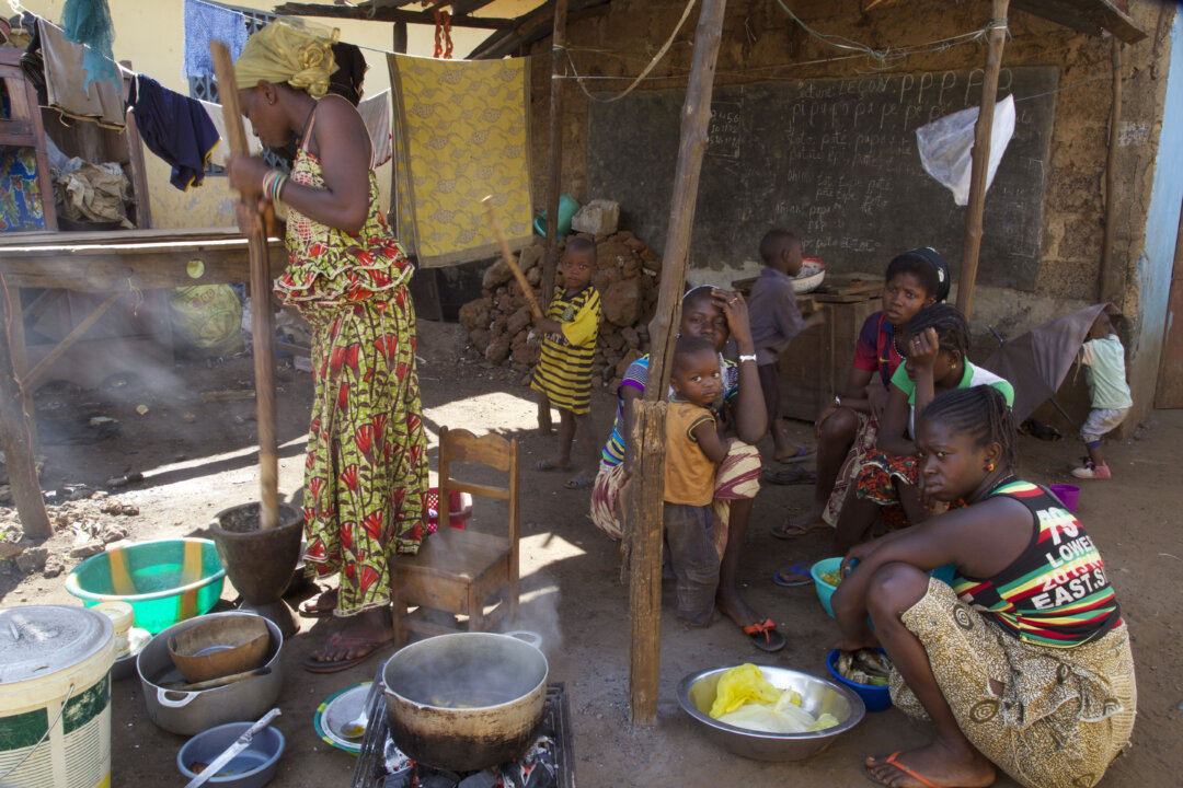 People prepare food at a homestead in Conakry City, Guinea, on Dec. 29, 2015. (AP Photo/Youssouf Bah)