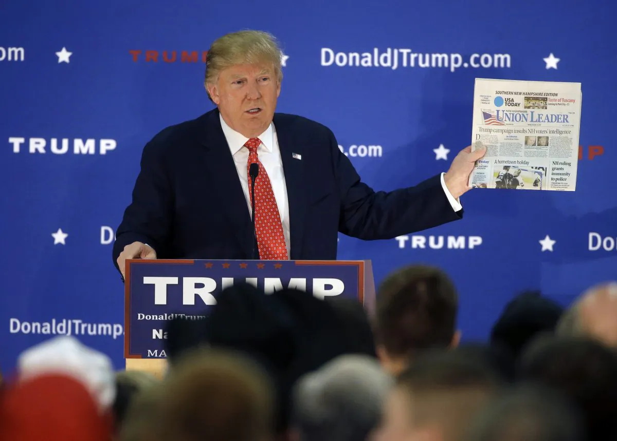 Republican presidential candidate Donald Trump displays a copy of the Union Leader newspaper while addressing an audience during a campaign event Monday, Dec. 28, 2015, in Nashua, N.H. (AP Photo/Steven Senne)