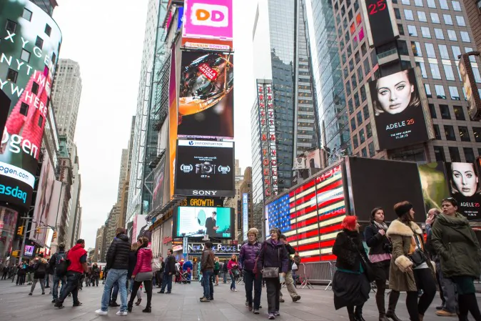 People walk in front of an NYPD station in New York's Times Square on Nov. 18, 2015. (Benjamin Chasteen/Epoch Times)