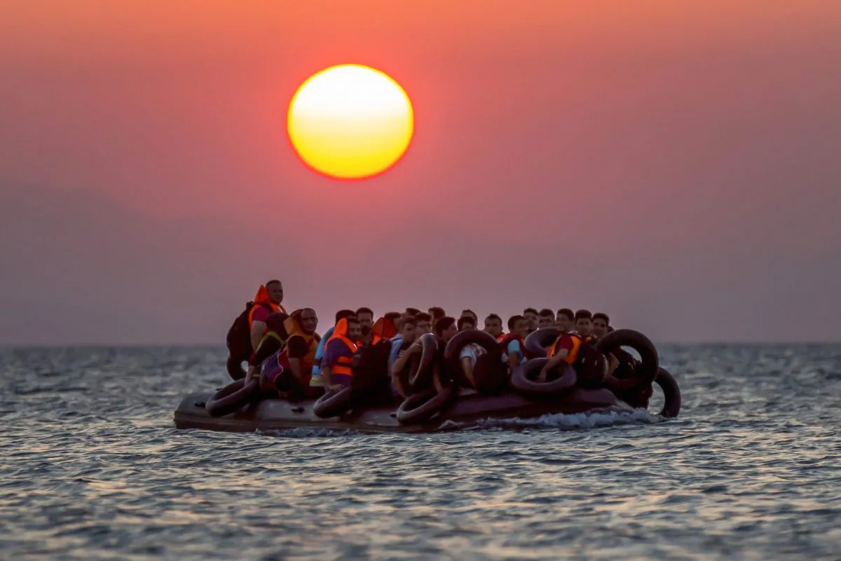 Migrants on a dinghy arrive at the southeastern island of Kos, Greece, after crossing from Turkey, on Aug. 13, 2015. (Alexander Zemlianichenko/AP Photo)