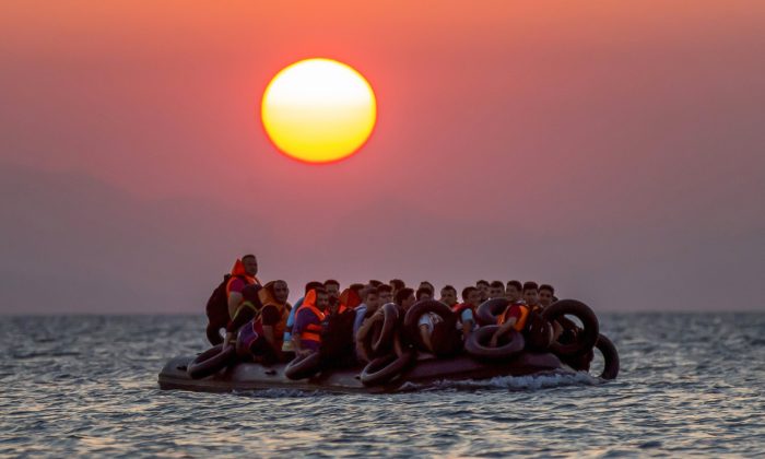 Migrants arrive in a dinghy on the island of Kos in southeastern Greece after crossing from Turkey on August 13, 2015.  (Alexander Zemlianichenko/AP Photo)