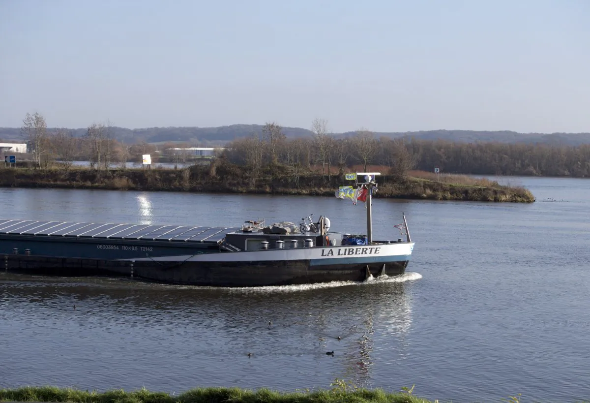 Dutch flagged ship passes by a Dutch owned island as it moves from Dutch owned waters into Belgian owned waters near Sint-Pietersberg, Netherlands, on Dec. 14, 2015. (AP Photo/Virginia Mayo)