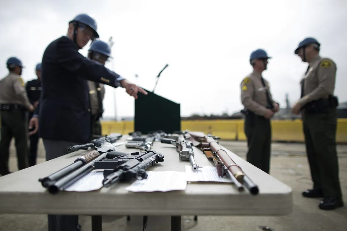 Officials look at confiscated guns prior to the destruction of approximately 3,400 guns and other weapons at the Los Angeles County Sheriffs' 22nd annual gun melt at Gerdau Steel Mill on July 6, 2015 in Rancho Cucamonga, California. (David McNew/Getty Images)
