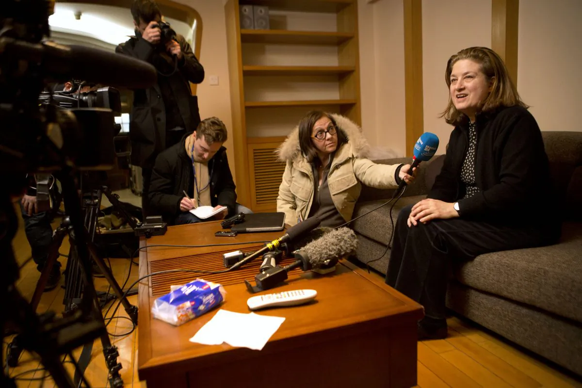 French journalist Ursula Gauthier (R) a reporter in China for the French news magazine L'Obs, speaks to the media in her apartment before leaving for the airport in Beijing on Dec. 31, 2015. (AP Photo/Mark Schiefelbein)