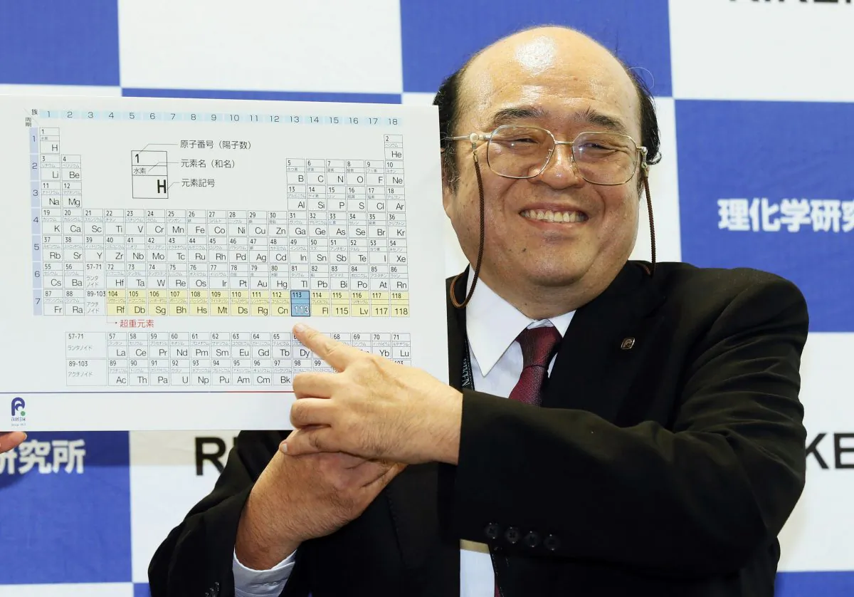 Kosuke Morita of Riken Nishina Center for Accelerator-Based Science points at periodic table of the elements during a press conference in Wako, Saitama prefecture, near Tokyo Thursday, Dec. 31, 2015.  (Kyodo News via AP)
