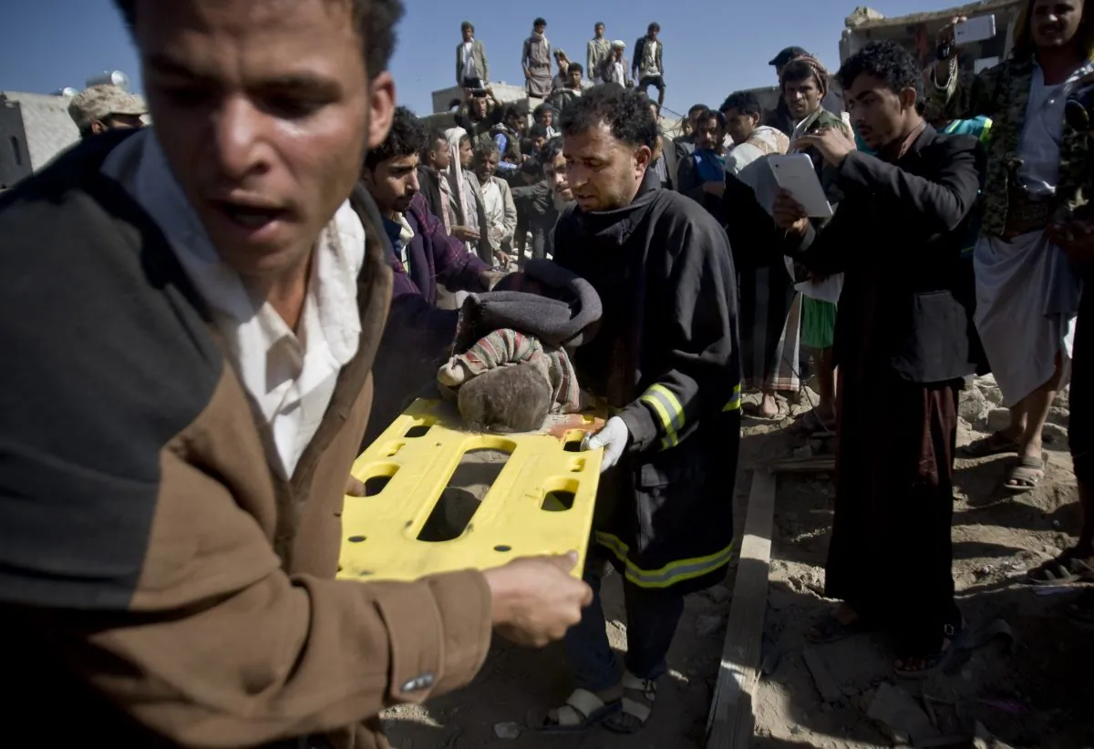 In this Thursday, March 26, 2015 file photo, people carry the body of a child they uncovered from under the rubble of houses destroyed by Saudi airstrikes near Sanaa Airport, Yemen. (AP Photo/Hani Mohammed)