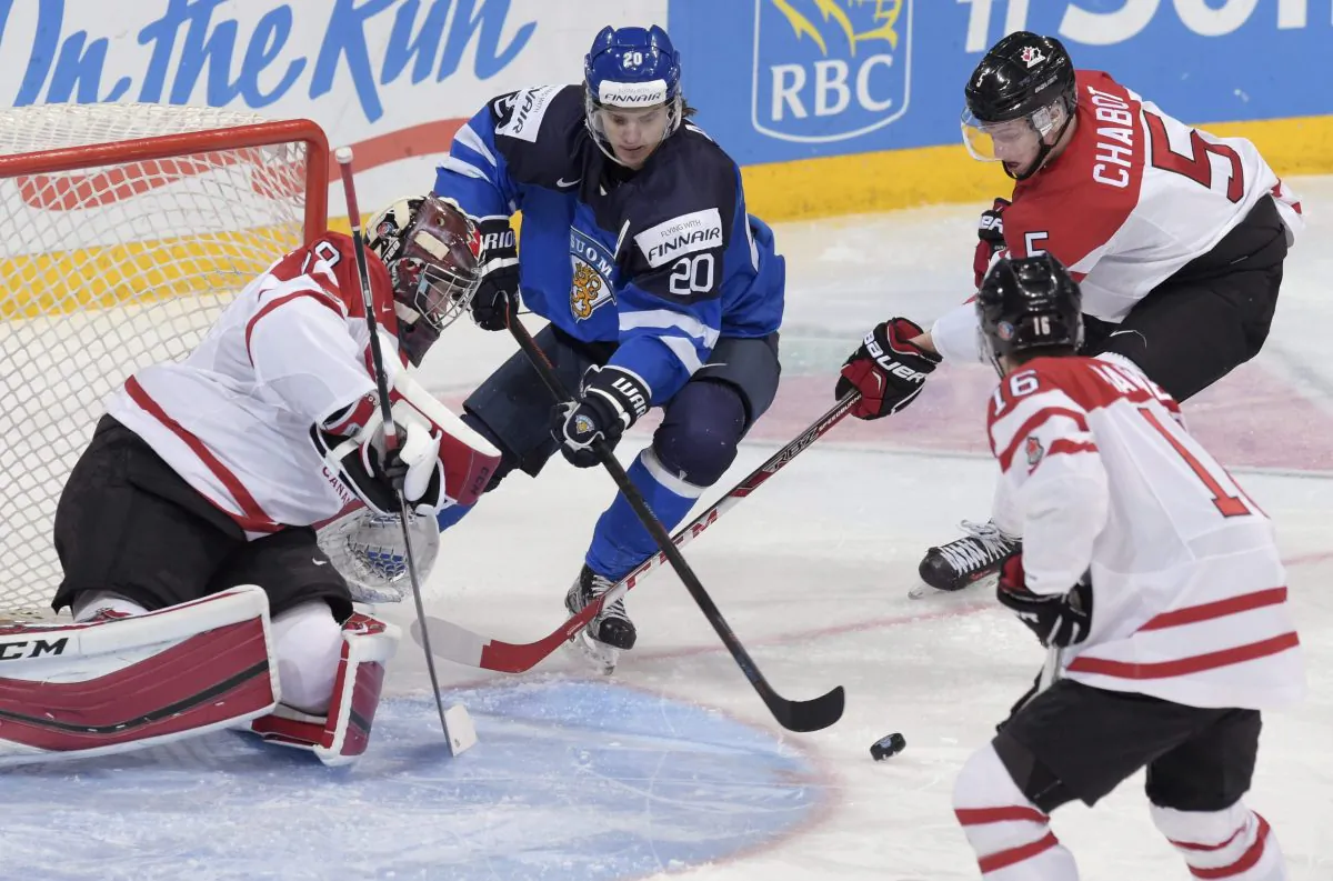 Finland's Sebastian Aho goes for a loose puck against Canada's goalie Mackenzie Blackwood, Mitch Marner, and Thomas Chabot at the 2016 IIHF World Junior Ice Hockey Championships quarterfinal in Helsinki, Finland on Jan. 2, 2016. (Markku Ulander/Lehtikuva via AP) 
