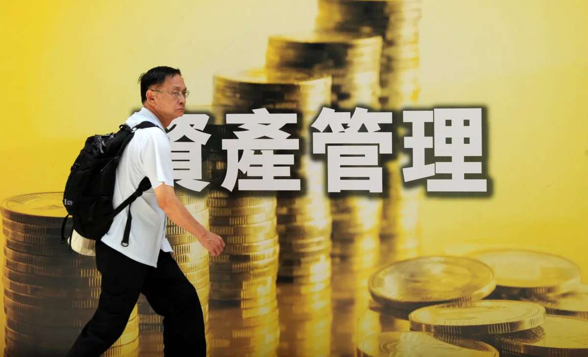A pedestrian walks past an advertisement for investment related products in Hong Kong on June 21, 2010. (Mike Clarke/AFP/Getty Images)