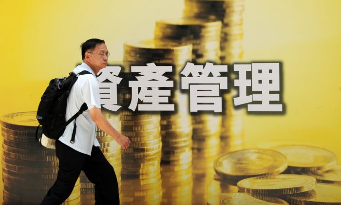 A pedestrian walks past an advertisement for investment related products in Hong Kong on June 21, 2010.  (Mike Clarke/AFP/Getty Images)