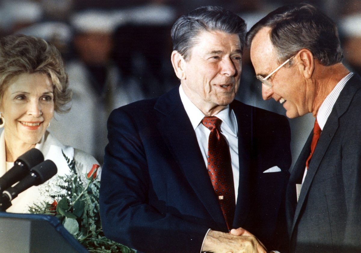 President Ronald Reagan (C) shakes hands with Vice President George Bush (R) as First Lady Nancy Reagan (R) looks on June 3, 1988, at Andrews Air Force Base, Maryland. (Luke Frazza/AFP/Getty Images)